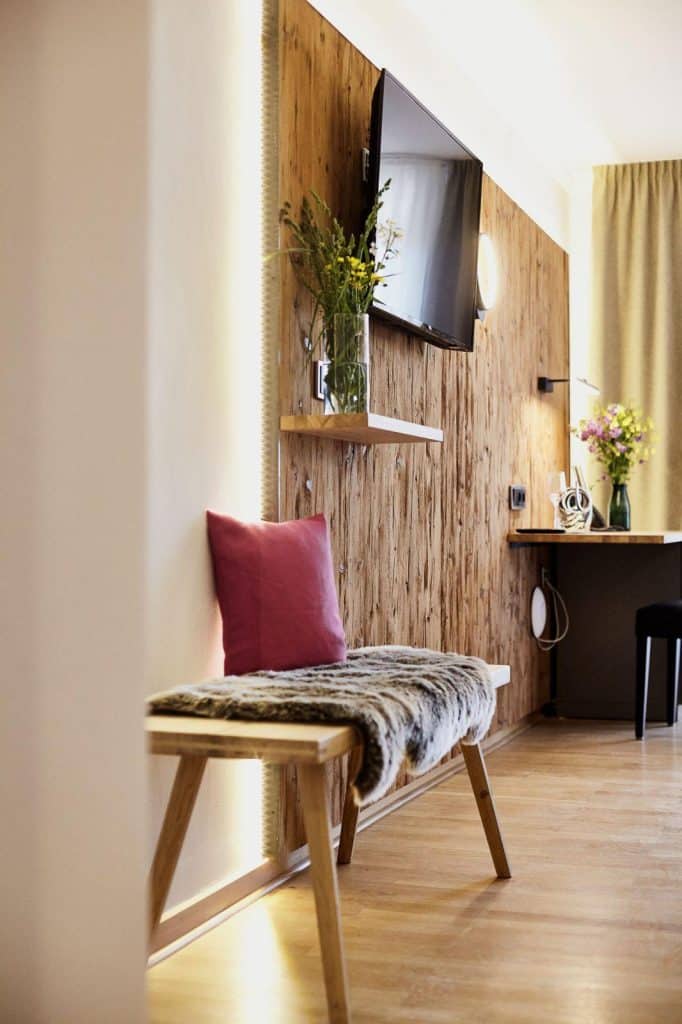 Hotel Gut Edermann Ausschnitt Zimmer, Holzwand mit Schreibtisch, TV, Sitzbank