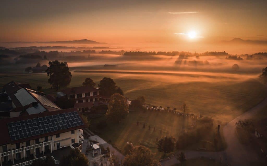 Hotel Gut Edermann Drohnenaufnahme im Morgenlicht Gut mit Feldern und Bergen