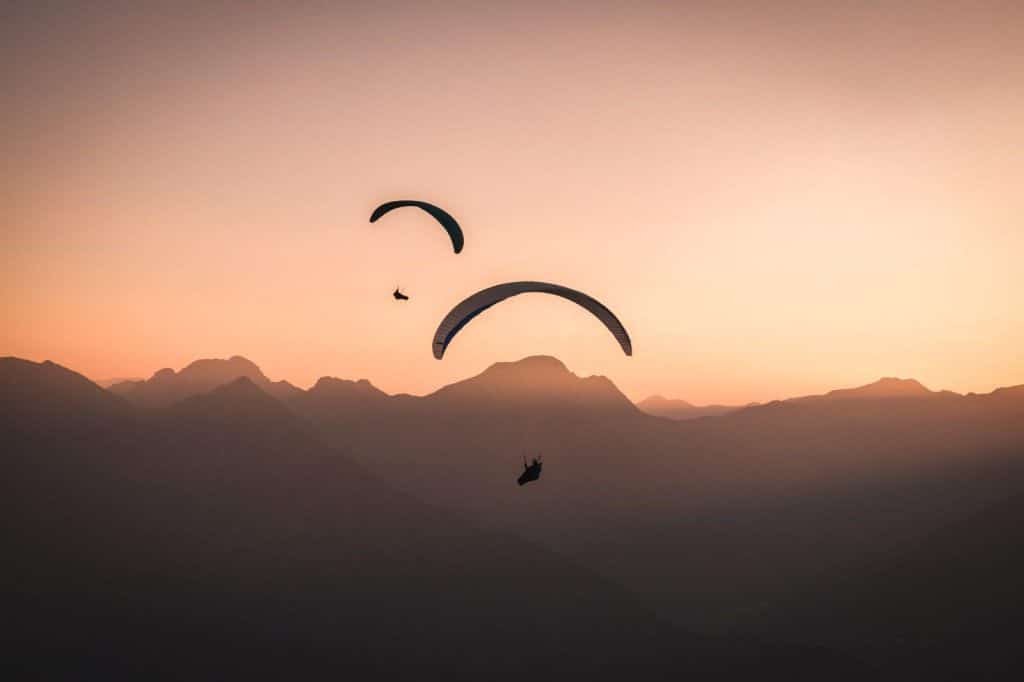 Paraglider vor Bergen im Sonnenuntergang